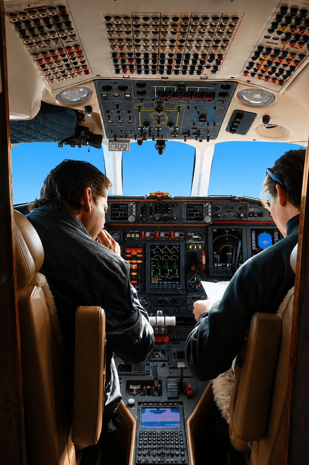 Two pilots reviewing a flight plan in the cockpit